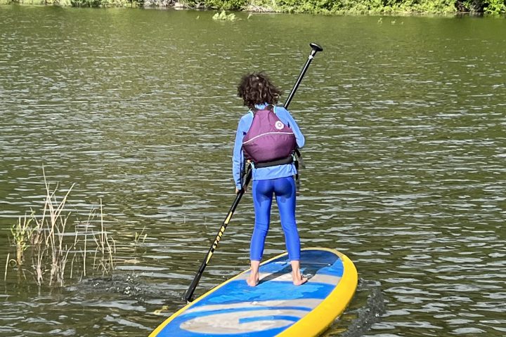 a person riding on the back of a boat in a body of water