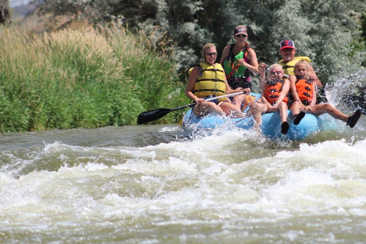 Family river rafting the class II whitewater of the Weber River in Utah