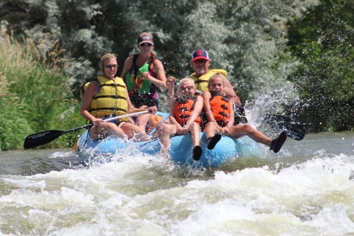Family river rafting the class II whitewater of the Weber River in Utah