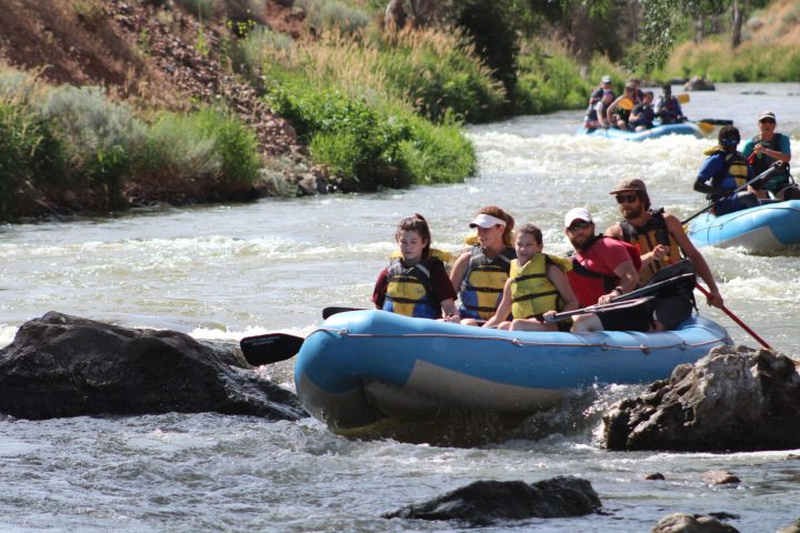 a group of people in a small boat in a body of water