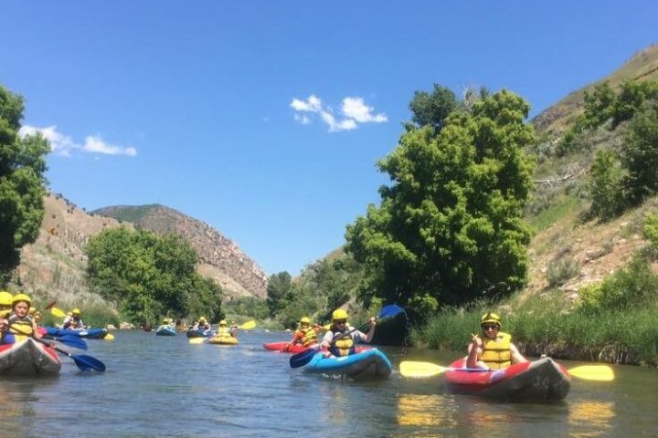 a group of people riding on the back of a boat in the water