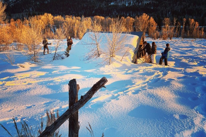 a group of people standing on top of a snow covered field