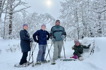 Carney Lansford et al. standing on top of a snow covered slope