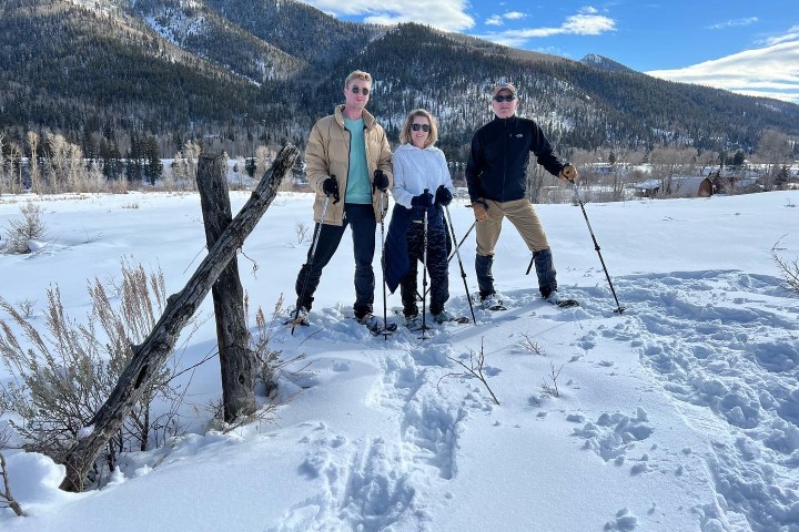 a group of people riding skis down a snow covered mountain