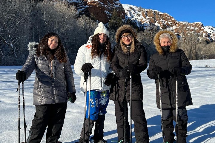 a group of people posing for a picture on a snow covered slope