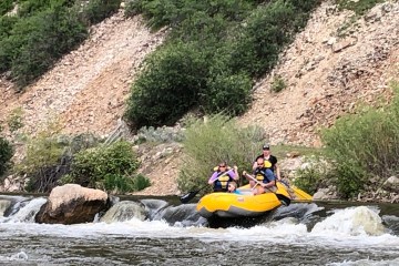a group of people on a raft in a river