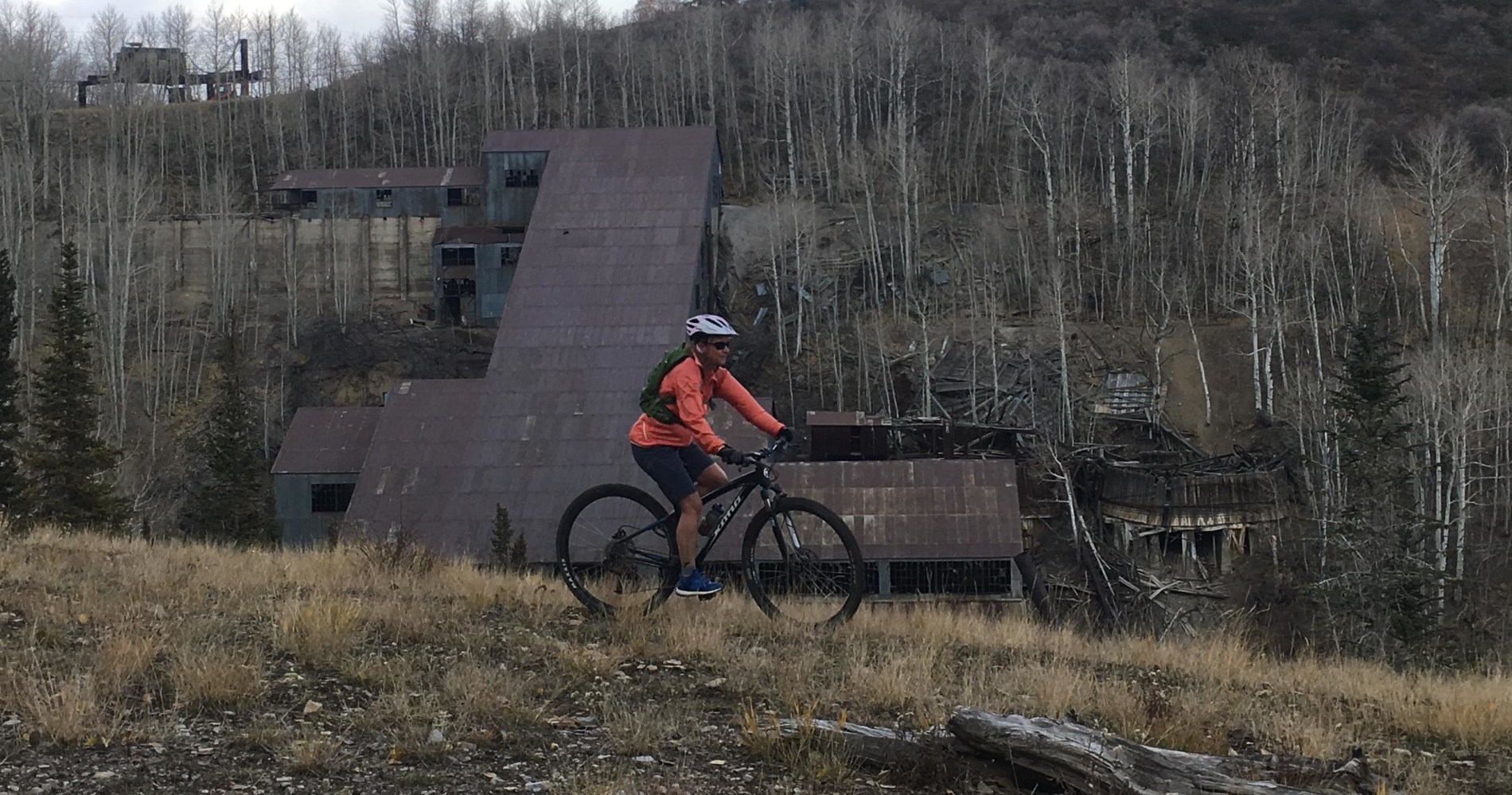 a man riding a bike down a dirt road