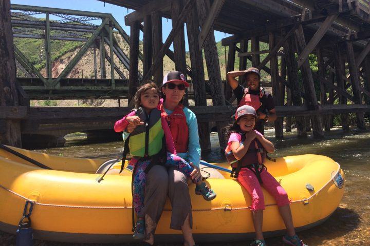 Family rafting, stopping for a rest at a train bridge