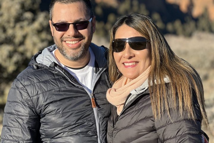 a man and a woman standing in front of a mountain