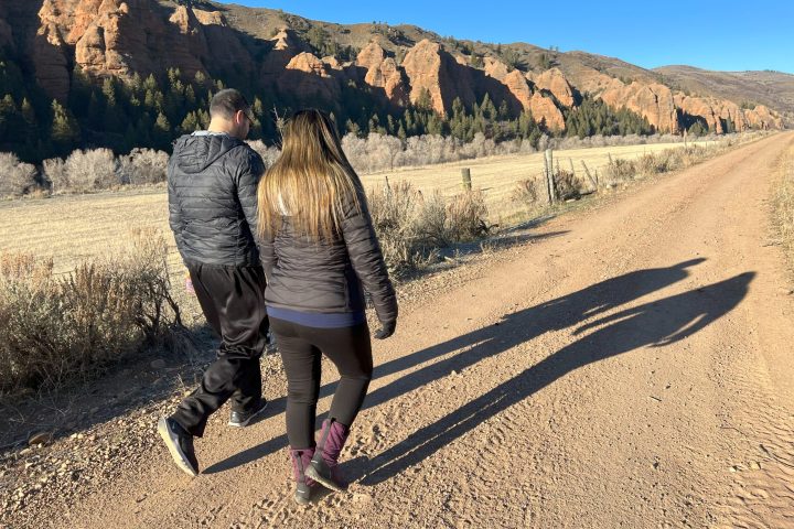 people hiking along red cliffs