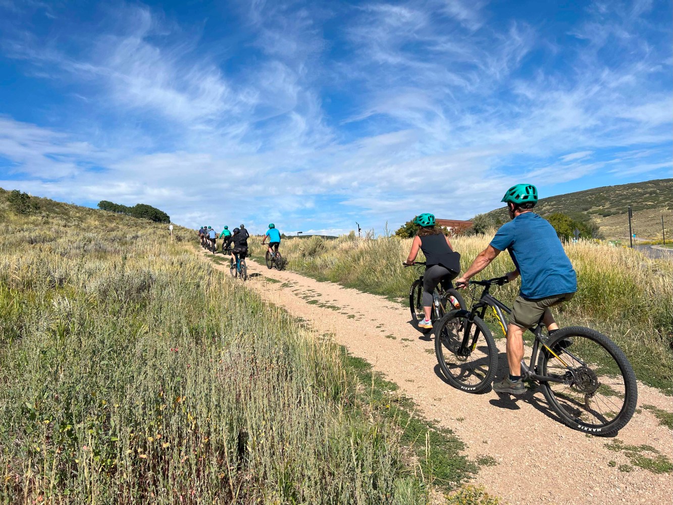 a man riding a bike down a dirt road