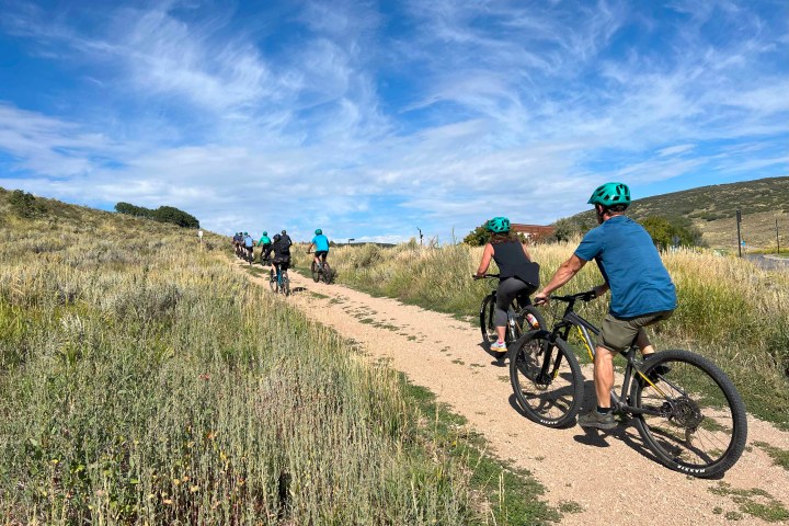 a man riding a bike down a dirt road